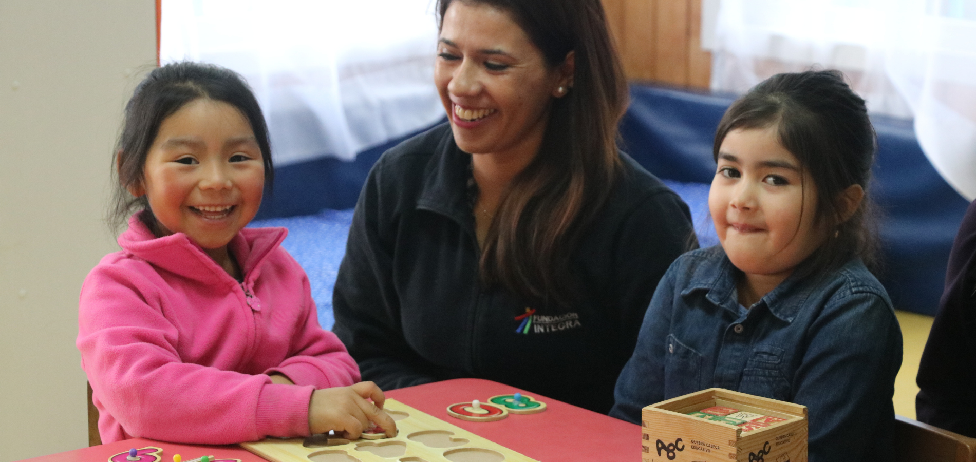 Imagen de educadora y dos alumnos en el jardin infantil chileno Ala Ala Hueñi